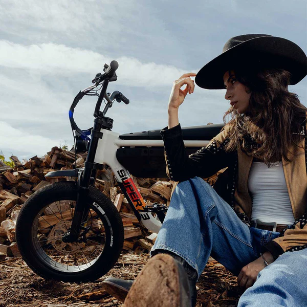 Rider with hat beside a white A-Series bike