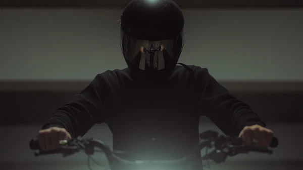 Rider in a full-face helmet gripping the handlebars